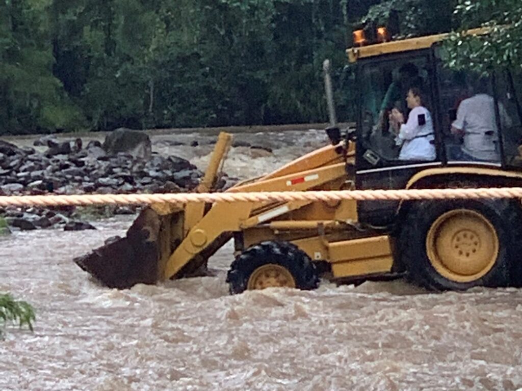 Our Guests crossing a flooded creek in a backhoe