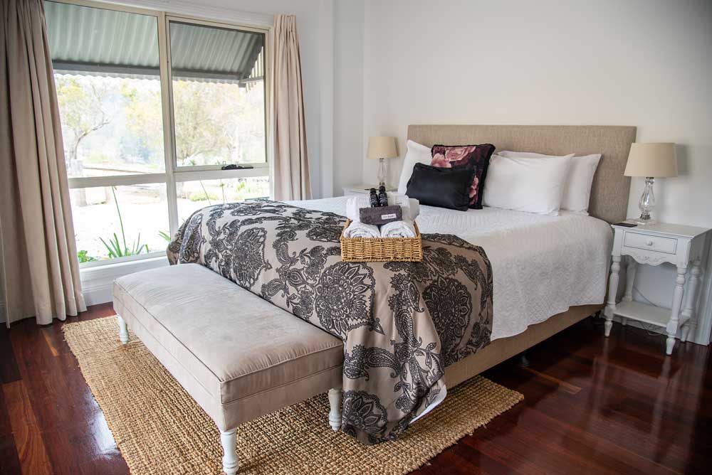 A king-size bed made up with quality linen for a slow morning in the cottage