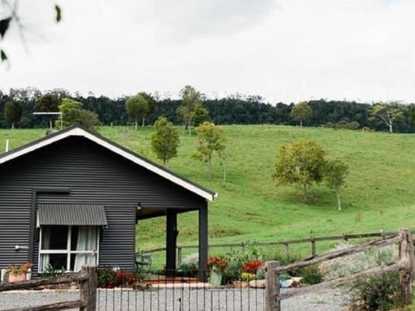 The Aerial, a grey country-style cottage surrounded by green rolling hills and trees
