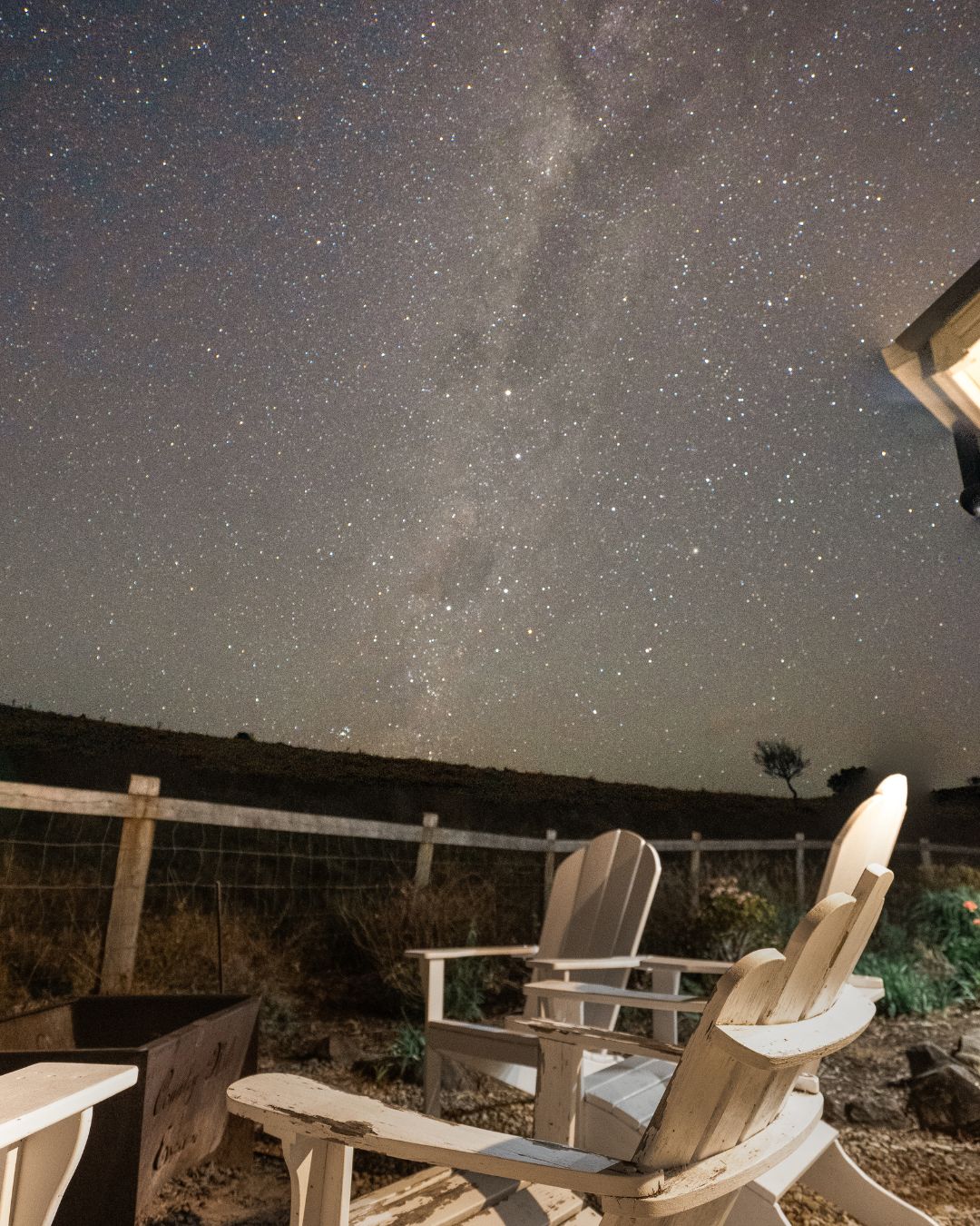 White chairs around a fire pit under a starry night sky at Country Mile Escape in the Scenic Rim
