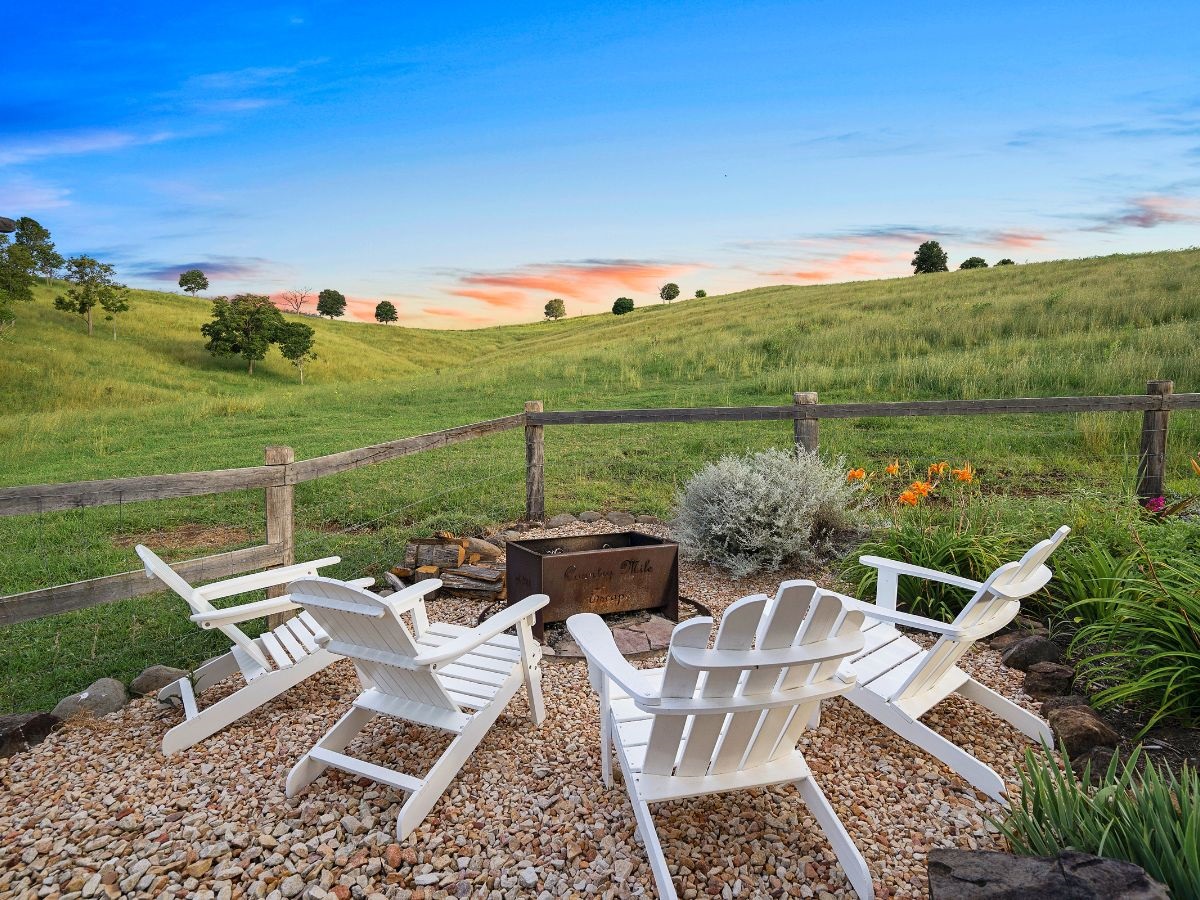 White chairs positioned around the fire pit with amazing views of Country Mile Escape
